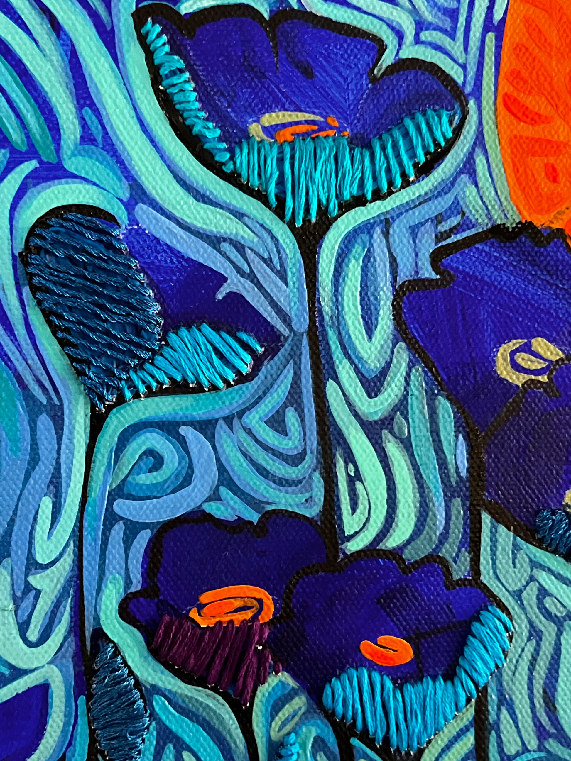 Close-up of embroidered floral patterns with blue, purple, and orange colors.